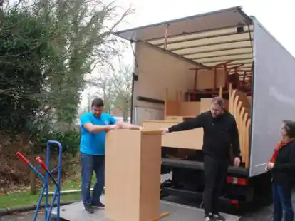 Wilhelm Kowalski und Daniel Springer laden die alten Schulm&ouml;bel auf. Schulleiterin Susanne Tapken hatte acht Klassens&auml;tze kostenlos abzugeben.