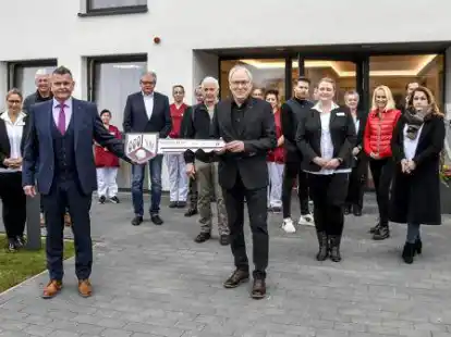Mitarbeiter und G&auml;ste verfolgten die Schl&uuml;ssel&uuml;bergabe von Architekt Hartmut Kapels (vorn rechts) an Pflegebutler-Gesch&auml;ftsf&uuml;hrer Heiko Friedrichs.
