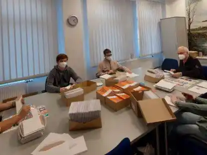 Zuordnen und verpacken: Im Rathaus werden die Bescheide und das Infomaterial zusammengestellt.