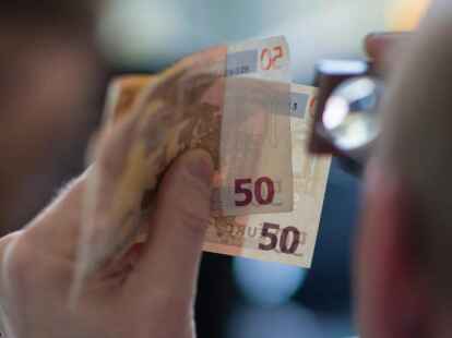 Pr&uuml;fender Blick: Wegen den Corona-Einschr&auml;nkungen ist weniger Falschgeld im Umlauf. Foto: Andreas Arnold/dpa/Illustration