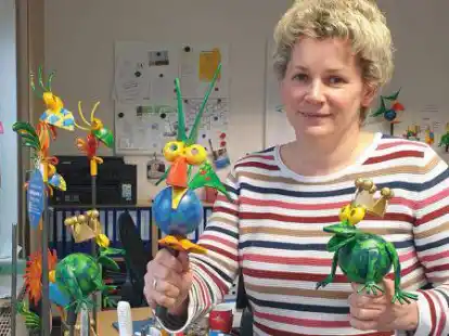 Sie sind bei vielen Einheimischen und G&auml;sten beliebt: Figuren der Aper Lieblingsorte.  Touristik-Mitarbeiterin Sandra Hinrichs mit der Aper Blauralle und dem Holtgaster Froschk&ouml;nig.