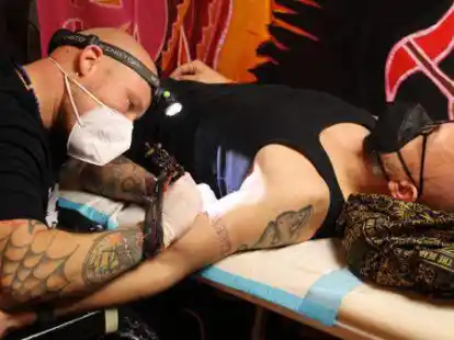 T&auml;towierer Mario Engelhardt mit seinem Kunden Holger Vos aus Oldenburg. Dieser l&auml;sst sich einen Rongorongo-Schriftzug von den Osterinseln stechen.