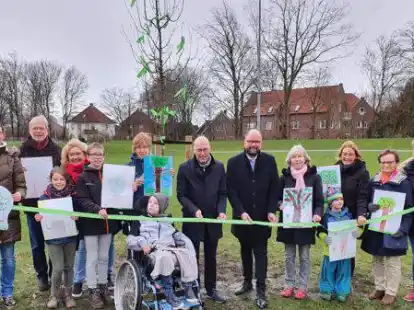 Das &bdquo;Gr&uuml;ne Band&ldquo; der Hoffnung halten in den H&auml;nden Koordinatorin Anne-Christine Baro (von links), Vorsitzender Gregor M&ouml;ller-Reemts, Koordinatorin Hildegard Meyer, B&uuml;rgermeister Neidhard Varnhorn und Landrat Johann Wimberg mit ehrenamtlichen Mitarbeiterinnen und Familien sowie Karin Kellermann (rechts).