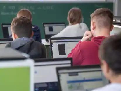 Sch&uuml;lerinnen und Sch&uuml;ler nehmen im Klassenzimmer einer 9. Klasse  am Unterricht mit Hilfe von Laptops und Tablets teil.