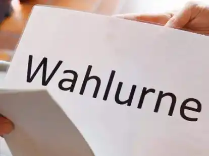 In einem Wahllokal wird ein Stimmzettel in eine Wahlurne geworfen.