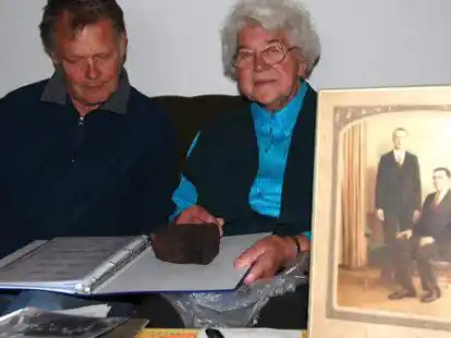 Bl&auml;ttern im Familienalbum: Ahnenforscher Hinrich Gast und Anneliese Kampen, Nichte des Auswanderers Klaas Janssen de Vries, mit dem St&uuml;ck Torf, das den Auswanderer zeitlebens an seine Heimat in S&uuml;dcoldinne erinnerte.