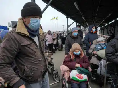 Menschen warten an einem Grenz&uuml;bergang zwischen den von prorussischen Separatisten kontrollierten Gebieten und den von der ukrainischen Regierung kontrollierten Gebieten. Westliche L&auml;nder rechnen jetzt mit einem gro&szlig;en Zustrom von Gefl&uuml;chteten aus der Ukraine. Auch der Landkreis Oldenburg bereitet sich darauf vor.