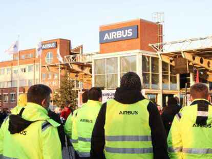 W&auml;hrend einer Aktion zur Aufsichtsratssitzung von Airbus stehen Mitglieder der IG Metall mit Transparenten und Schildern vor einem Werkstor von Airbus in Hamburg-Finkenwerder. Nach Gewerkschaftsangaben haben rund 300 Besch&auml;ftigte gegen die Umbaupl&auml;ne des Konzerns demonstriert. +++ dpa-Bildfunk +++