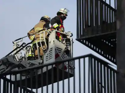 Mitarbeiter der Feuerwehr begutachten den Schaden am Wohnkomplex in Essen. Foto: David Young/dpa