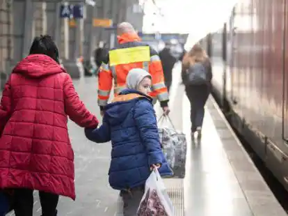 Fl&uuml;chtlinge aus der Ukraine kommen vermehrt in Deutschland an. Dieses Bild zeigt eine Frau mit ihrem Jungen, die mit einem Zug aus der Ukraine gekommen ist und an einem Bahnhof in Hessen von Helfern in Empfang genommen wird (Symbolfoto).