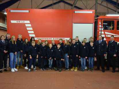 Die Jungen und M&auml;dchen der Jugendfeuerwehr Ramsloh mit Gemeindejugendfeuerwehrwart Jan Wasserthal (von links), Felix Fugel, Thede Henken und Annika Tebben sowie Niklas B&ouml;hmann (von rechts), stellv. Ortsbrandmeister Timo Hinrichs, Ortsbrandmeister Matthias Schulte und Jugendfeuerwehrwart Florian Fugel.