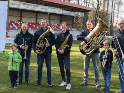 Sie laden Musikerinnen und Musiker in das Oyther Stadion &bdquo;An der Hasenweide&ldquo; ein (hinten, v.l.): Heinrich Windhaus, Ralph und Kristina Ellert, Ulrich Wichmann und Michael Windhaus und die beiden Nachwuchsmusiker Johann und Linus.