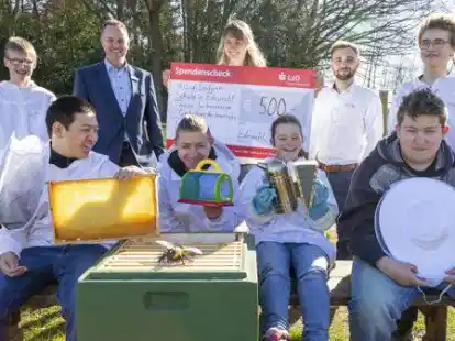Unterst&uuml;tzung f&uuml;r die Imker-AG der Astrid-Lindgren-Schule: Die LzO-Mitarbeiter Jan-Olrik Sch&uuml;rmann (hinten, 2.v.l), und Jannis Bente (hinten, 2.v.r.) &uuml;bergaben die F&ouml;rdersumme an Lehrerin Sandra Scharpekant (hinten, 3.v.l.) und Sch&uuml;lerinnen und Sch&uuml;ler der Klasse 9 A.