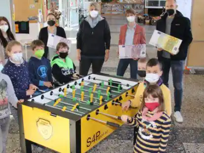 Ein Kickertisch f&uuml;r die Grundschule Gro&szlig;enkneten: Dar&uuml;ber freuen sich nicht nur die Kinder (von links) Lennard, Anna, Jakob, Sammy, Jonas, Ben und Alina, sondern auch (dahinter von links) Lena Schw&ouml;ppe (VR Bank Oldenburg Land), Anja Schwarzer (F&ouml;rderkreis), Anja Adler (Stellvertretende Schulleiterin), Birthe Voigt (F&ouml;rderkreis) und Henning Butt (Firma Butt).