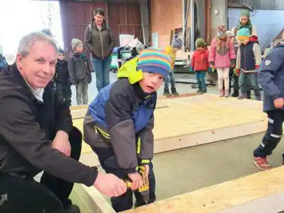 Heiko Posegga (links) zeigte den Kita-Kindern, wie man mit dem Schrauber die Elemente f&uuml;r die Holzrahmenbau-W&auml;nde zusammenf&uuml;gt.
