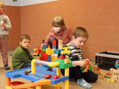 W&auml;hrend die Eltern im Franziskushaus erste Vokabeln b&uuml;ffeln und mit der B&uuml;rokratie k&auml;mpfen, k&ouml;nnen Veronika (4, von links), Nikita (6) und Max (5) mit Heilp&auml;dagogin Ulrike Stock spielen. Foto: