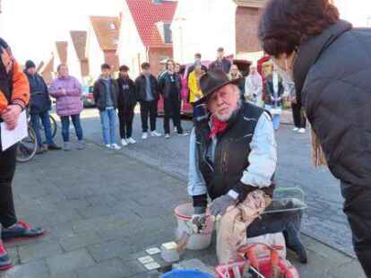 Seltener Moment: Der vor Ort sonst eher schweigsame Stolperstein-Initiator Gunter Demnig l&auml;sst sich von Arbeitskreis-Sprecherin Edda Melles die Information entlocken, dass er noch in diesem Jahr europaweit den 90.000. Stolperstein verlegen wird. Links: IGS-Sch&uuml;ler Matthias ten Hove (16), der in der Godfried-Bueren-Stra&szlig;e 23 die Biografie von Berend H&uuml;ndling verlas. Dieser war wegen seiner politischen Arbeit f&uuml;r die KPD von den Nazis verfolgt worden.