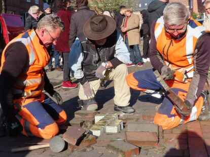 Karl-Heinz Giesen und Horst Davids vom Bau- und Entsorgungsbetrieb Emden unterst&uuml;tzen Stolperstein-K&uuml;nstler Gunter Demnig.