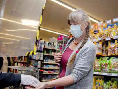 Einer Kundin bezahlt in einem Supermarkt, wobei sie einen Mund-Nasen-Schutz tr&auml;gt. Die Pflicht zum Tragen einer Maske ist im Einzelhandel seit dem 2. April aufgehoben. (Symbolbild)