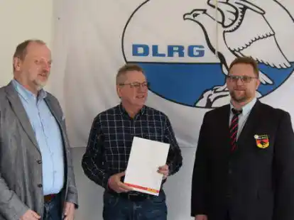 Der stellvertretende DLRG-Bezirksvorsitzende Ralf Dorendorf (links) und der Ortsgruppenvorsitzende Bodo Pachal (rechts) gratulierten dem Jubilar Detlef Frobenius (von links).