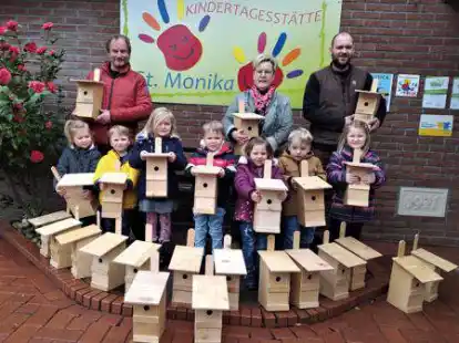 Tischlermeister Hans Deeken (links) und Bernd H&ouml;gemann (rechts) &uuml;bergaben die ersten 25 Nistk&auml;sten an die Kinder und Kita-Leiterin Jutta Hoff.