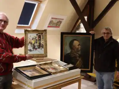 Heinrich Deboi (links) und Wolfgang Letzel zeigen Teile der geschenkten Bilder der Museumsstiftung Post und Telekommunikation Frankfurt.