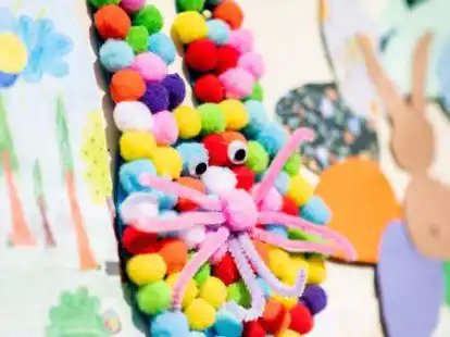 Ein bunter Osterhase, den ein Kind gebastelt hat, h&auml;ngt vor dem Gemeindehaus an einer Stellwand.