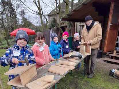 Schlechtes Wetter macht ihnen nichts aus: Unter der Anleitung von Dr. Wulf Carius (rechts) bastelten Kinder Nistk&auml;sten.