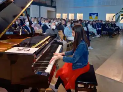 Hannah Si Jia Wille (am Klavier) spielte die Eigenkomposition &bdquo;Erinnerungen&ldquo;. Das perfekte St&uuml;ck f&uuml;r die 100-Jahr-Feierstunde im Forum der Graf-Anton-G&uuml;nther-Schule.