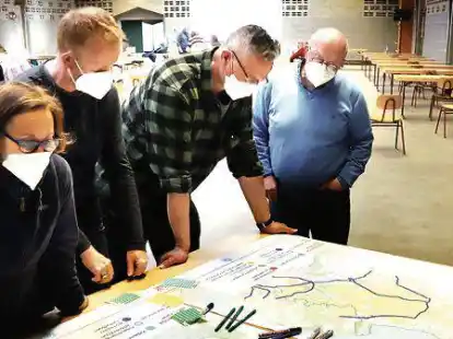 Teilnehmer eines B&uuml;rgerworkshops in Varel zum geplanten Fahrradkonzept f&uuml;r den Landkreis Friesland notieren ihre W&uuml;nsche und Anliegen auf bereitgestellten Karten, die den bisherigen Planungsstand zeigen.