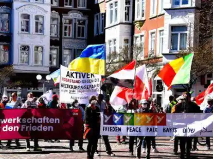 Menschen treten f&uuml;r den Frieden und gegen Gewalt auf dem B&ouml;rsenplatz ein. Auf ihrem Marsch durch die Stadt zeigten sie die Flaggen der L&auml;nder, in der derzeit ein Krieg tobt.
