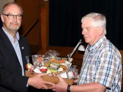 Der  Vorsitzende Hergen Stolle (links) &uuml;berreicht dem langj&auml;hrigen Kassenwart Gerd Hespe-Meyer (rechts) einen Pr&auml;sentkorb.
