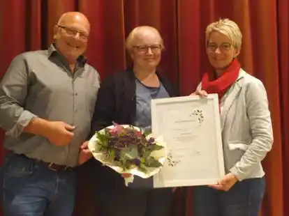 Anja Behnke (Mitte) wurde f&uuml;r ihre 40-j&auml;hrige Mitgliedschaft beim Musikkorps geehrt. Der Zweite Vorsitzende Ralf P&ouml;perny (links) und Gesch&auml;ftsf&uuml;hrerin Conny Wolter (rechts) &uuml;berreichten ihr Blumen und eine Urkunde.