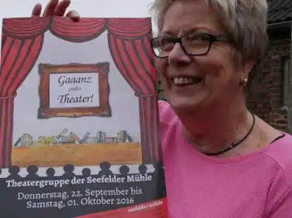 Heike Barre mit einem Plakat der Theatergruppe der Seefelder M&uuml;hle.