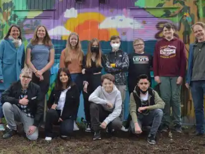 Sind von dem Ergebnis begeistert: Heike Burggr&auml;f (JUSTiQ, hinten von links), Victoria L&uuml;bben, Manja Behrens, Oliva Wieko, Tom Hartwig, Nick Asbrock,  Maksymilian Skalrski und Jost Friedebold (p&auml;dagogische Leitung JUSTiQ) sowie Mantas Kaulinis (unten, von links), Batoul Almeshaal, Etienne Giron und Sedar Al Hano vor dem Graffito.