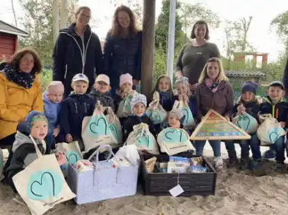 Reichhaltig beschenkt: Die Vorschulkinder der Kiga Steinhausen freuen sich &uuml;ber Geschenkbeutel, Spielzeug und regionale Lebensmittel. (Von hinten links): Tanja Hellmers und Sylvia Bruns, &bdquo;Muddis&ldquo;, Sandra Leonhard Marketing der Molkerei Ammerland und die Erzieherinnen (von vorne links): Ilona R&ouml;ben, Julia Timmermann und die Kita-Leitung Sandra Henning.