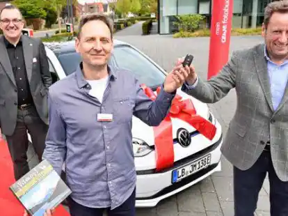 Cewe-Vorstand Thomas Mehls (links) und Uwe St&ouml;ver (Autohaus Braasch) gratulierten Jochen Fisches, Gewinner des Cewe Fotobuch-Wettbewerbs aus Stuttgart.