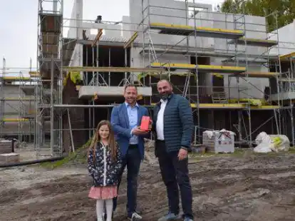 B&uuml;rgermeister Sven Stratmann (rechts) &uuml;berreichte Projektleiter Timo Engelhardt ein Geschenk beim Richtfest f&uuml;r den neuen Senioren-Wohnpark in Friesoythe.
