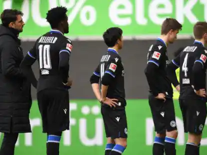 Nach dem 0:4 beim VfL Wolfsburg stehen die Spieler von Arminia Bielefeld mit gesenkten K&ouml;pfen auf dem Platz. Foto: Swen Pf&ouml;rtner/dpa