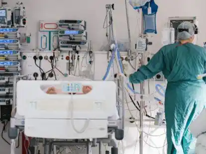 Eine Intensivpflegerin versorgt auf der Intensivstation  einen an Covid-19 erkrankten Patienten.