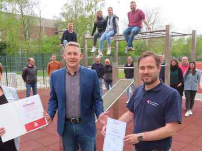 Gemischtes Doppel im Calisthenics-Park des JAG: Insa Bruns-Breninck von der Sparkasse Emden &uuml;berreichte an Schulleiter Oliver Damm die Urkunde f&uuml;r den dritten Platz im bundesweiten Sportabzeichen-Wettbewerb, Schulsport-Fachberater Henning Bach die Urkunde zur Auszeichnung als &bdquo;Sportfreundliche Schule&ldquo;.