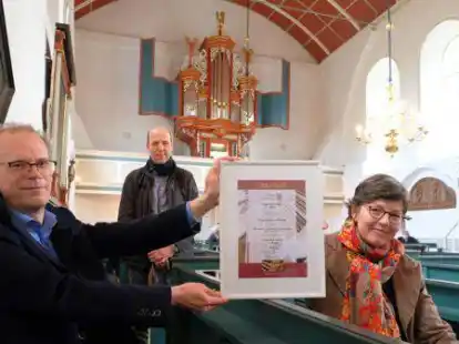 Moderne Zeit: Die Kirchenorgel in Uttum wurde 2021 sogar Deutschlands Kirchenorgel des Jahres. Dr. Catharina Hasenclever &uuml;berbrachte dem Kirchenratsvorsitzenden Christian Jan&szlig;en die Urkunde unter den Augen von  Orgelbaumeister Hendrik Ahrend.