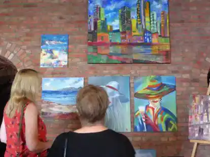 Kunstinteressierte vor Aquarellen der letzten Ausstellung aus dem Jahr 2019.