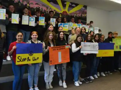 Die Klassensprecher und Sch&uuml;lervertreterinnen der Oberschule Ganderkesee haben Andreas Lange von der Initiative &bdquo;Ganderkesee hilft&ldquo; (Mitte) einen Scheck &uuml;berreicht. Bei vielen Aktionen kam Geld f&uuml;r die Ukraine zusammen.