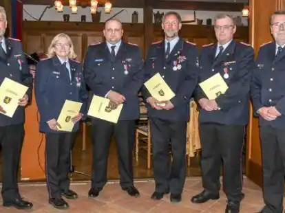 Kreisbrandmeister Gerhard Zunken (rechts) mit den Empf&auml;ngern der Verdienstmedaille des Kreisfeuerwehrverbandes: (von links) Reiner Hinrichs, Gunda Burmann, Pascal Weber, Holger Leichter und Horst Hilbers