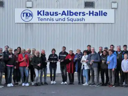 Symbolisch f&uuml;r die Einweihung der Klaus-Albers-Halle schnitten der TKN-Vorsitzende Michael Eppler und Finanzwartin Kerstin Reinstrom (Mitte) ein Band vor dem neuen Hallenschild durch.