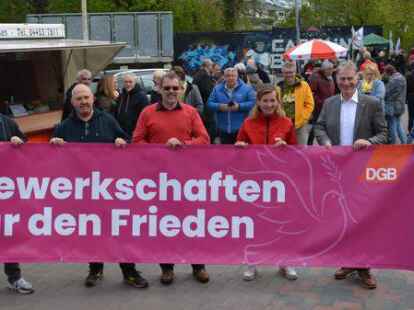 Setzten bei der Maikundgebung in der Weberei in Varel auch ein Zeichen f&uuml;r den Frieden: (von links) Marcus Baitis, IG-Metall-Vertrauensk&ouml;rperleiter bei Premium Aerotec, Ernst-August M&uuml;lschen von der IG-Metall, DGB-Kreisverbandsvorsitzender Lothar Bredemeyer, Bundestagsabgeordnete Siemtje M&ouml;ller, B&uuml;rgermeister Gerd-Christian Wagner und Landrat Sven Ambrosy