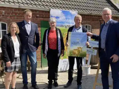 Herbert Heyen (rechts) &uuml;berreichte Familie B&uuml;sing (von links: Klaudia, Torsten, B&auml;rbel und Gerold B&uuml;sing) das Hofschild, das sie als einen der besten Milcherzeuger  Niedersachsens 2021 auszeichnet.