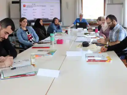 Mit Dozentin Ulla L&uuml;ck (Mitte) lernen die acht Teilnehmer gerade nach Silben deutsche W&ouml;rter lesen.