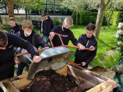 Gemeinsam angepackt: Sch&uuml;ler der KGS Hage-Norden beim F&uuml;llen eines Hochbeets &ndash; hier mit Kersten Ebel vom Nabu (rechts) &ndash; im Schulgarten, der in diesem Jahr komplett neu angelegt wird.